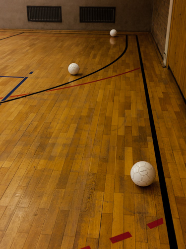 Spezielle Bälle, in denen eine Rassel eingebaut ist, liegen während des Torball-Traings auf dem Hallendboden verteilt.
