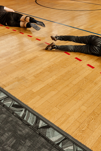 Beine der Torball-Spieler, die sich auf dem Spielfeld strecken um einen Ball abzuwehren.
