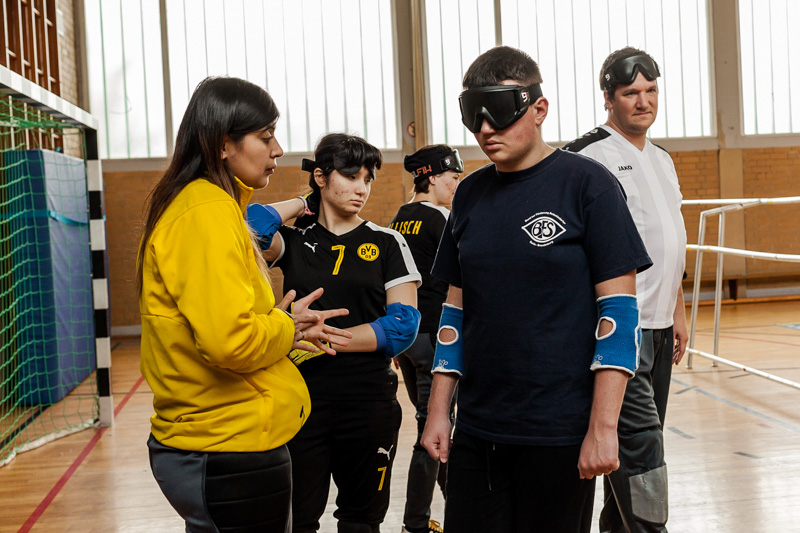 Spieler des Blindensports Torball tragen Dunkelbrillen während sie auf den Beginn des Trainings warten