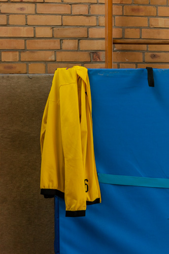 Eine gelbe Trainingsjacke des BVB hängt an einem an die Wand gelehnten Weichboden.