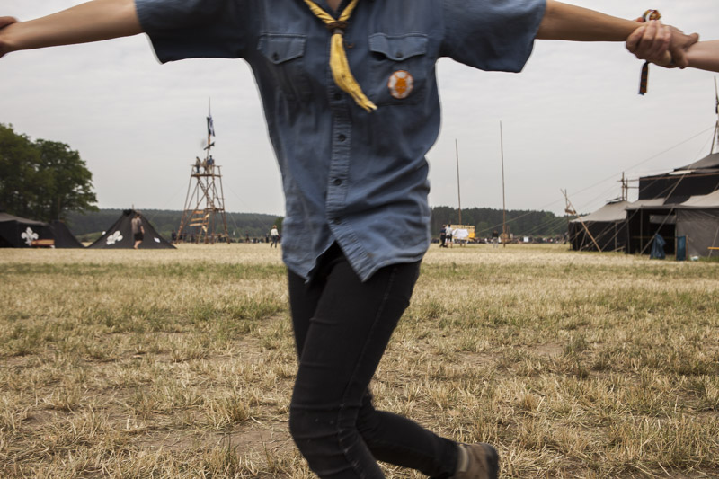 Pfadfinderinnen und Pfadfinder fassen sich beim Tanzen während eines Pfadfinderlagers in der Nähe von Allersdorf, Deutschland an den Händen. / Scouts hold hands while dancing during a scout camp near Allersdorf, Germany