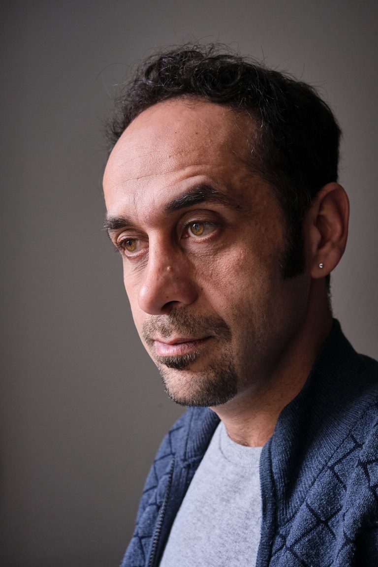 Portrait von  Puyan Mahmudian
| Doktorant in seiner Wohnung.
aus: „Zwischen Hoffnung, Schmerz und Entschlossenheit“ in chrismon plus
/ 2022