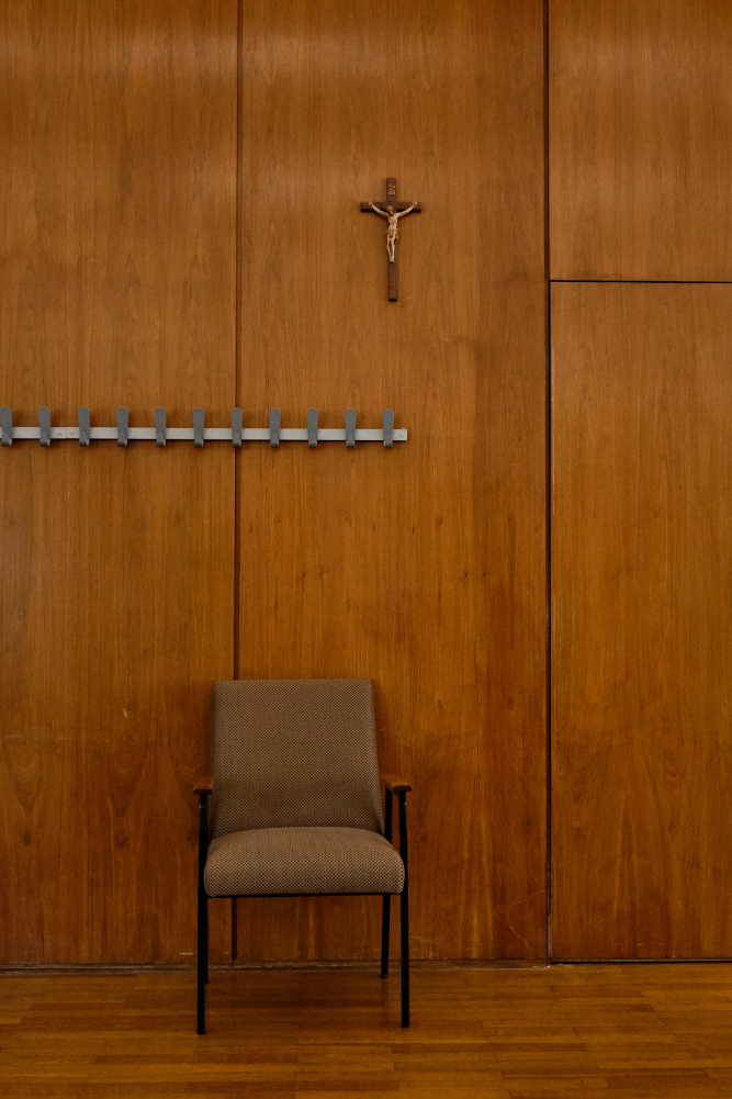 Wandvertäfelung mit Stuhl und Kruzifix im Ratssaal der Stadt Monschau, aufgenommen während eines Termins von Catarina dos Santos-Winz (MdB, CDU) mit dem Stadtrat von Monschau.

Wood-paneled wall with a chair and crucifix in the council chamber of the city of Monschau, captured during a meeting of Catarina dos Santos-Winz (Member of the Bundestag for the CDU) with the city council of Monschau.
