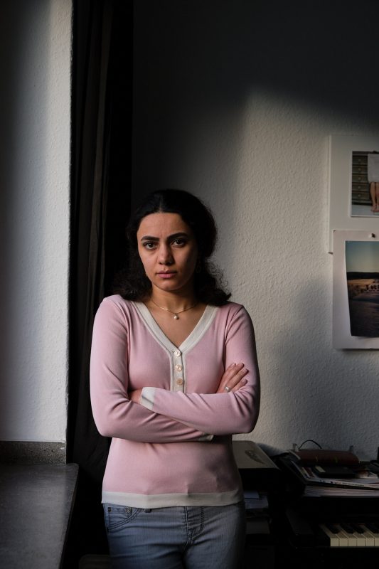 Portrait von Mina Abbas Panah in ihrer Wohnung in Dormtund. Mina gehört zur iranischen Diaspora in Deutschland. Aufgenommen am 15.11.2022 in Dortmund.

Mina Abbas Panah ist 30 Jahre alt und lebt in Dortmund. Sie kommt aus den kurdischen Gebieten im Westen Irans. Sie studierte Fotografie in Teheran und kam vor zwei Jahren nach Deutschland, um mit ihrem deutschen Ehemann zusammenzuleben. Seit sie ein Kind war träumte sie davon, den Iran mit seinen strengen, religiös begründeten Restriktionen, hinter sich zu lassen und in einem freieren Land zu leben. Doch seit sie in Deutschland lebt, ist ihr bewußt geworden, welch große Rolle der Iran immer noch für sie spielt und wie die Verbindung zu ihrem Heimatland eher noch stärker geworden ist. 

Zitat:"Das deutlichste Zeichen für mich, dass nun eine Revolution passiert, ist, das junge Schulmädchen landesweit ihre Kopftücher abnehmen und die Bilder von Khamenei und Khomenei abreissen und verbrennen. Sie leben den Traum, den sich meine Generation nie getraut hat zu träumen. Diese jungen Mädchen - die Zukunft des Irans - werden nicht stillhalten, wenn ihre grundlegenden Menschenrechte verletzt werden, sie werden für ihre Freiheit kämpfen. Wir wollen nicht aufgeben. Wir schulden das all den 16-Jährigen, die ihr Leben schon für die Freiheit gegeben haben. Wir tun alles um ihren Traum wahr werden zu lassen."