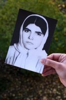 Aufsicht auf eine Fotografie der verstorbenen Tante Darya Latifpours´  gehalten von Darya. Aufgenommen am 16.11.2022 in Dortmund.

Darya’s Tante Razie wurde im Zuge von Massenexekutionen in den 80er Jahren im Evin-Gefängnis ermordet, ihre Leiche in einem Massengrab verscharrt. Obwohl Darya erst 3 Jahre nach ihrem Tod geboren wurde, war sie doch immer in ihrem Leben präsent. Als Kind erinnert sie sich daran, wie ihre Großmutter jeden Abend um ihre Tochter weinte.