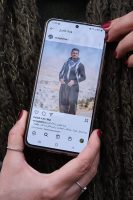 Aufsicht auf ein Portrait des iranischen Fussballspielers Vouria Ghafouri auf dem Bildschirm eines Smartphones gehalten von Sima. Aufgenommen am 25.11.2022 in Dortmund.

Vouria Ghafouri, ist ehemaliger Fussballnationalspieler des Irans. Er stammt, wie Sima, aus Sanandaj. Aufgrund seiner regimekritischen Haltung wurde er Ende November 2022 verhaftet und später auf 
Kaution freigelassen. 
Eigentlich hasst Sima Fussball, aber sie bewundert Vouria's Selbstlosigkeit, seinen Idealismus, und „beneidet“ seinen Mut.